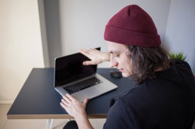 Sinirli kullanıcı dizüstü bilgisayarı kapatır. İşyerinde genç bir programcının iş yerinde sorunları var