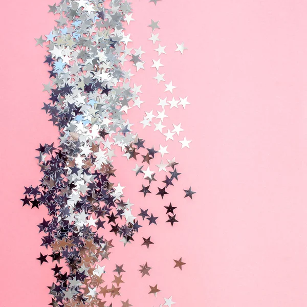 Yıldız şeklinde konfeti pembe bir arka plan üzerine dağılmış. Kutlama ve parti, konsept. Kopyalama alanı