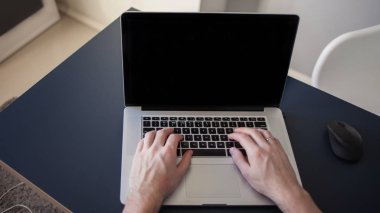 Bir dizüstü bilgisayar için tasarımcı, serbest çalışanlar için bir işyeri. Masada oturan genç bir adam.