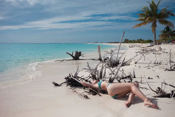 Belle fille en bikini couché parmi les épines de bois sur la plage — Photo
