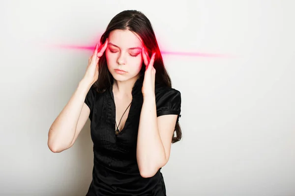 Genç bayan baş ağrısından muzdarip. Kafasını tutan bir kızın portresi. Migren ve kan basıncı sorunları