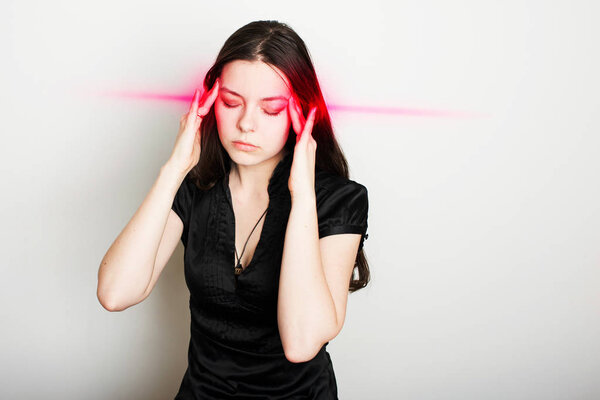 young woman is suffering from a headache. Portrait of a girl clutching her head. Migraines and blood pressure problems