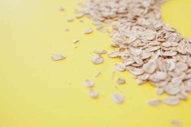 sağlıklı beslenme, kavram. Sarı bir arka plan üzerinde tahıl yulaf ezmesi. Yulaf gevreği dağınık