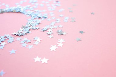 Yıldız şeklinde konfeti pembe bir arka plan üzerine dağılmış. Kutlama ve parti, konsept. Kopyalama alanı