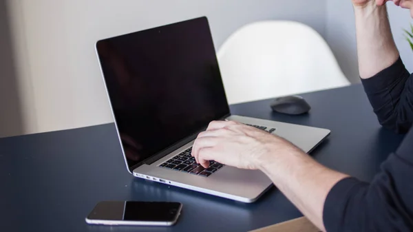 Дизайнер ноутбука, рабочее место для фрилансеров. Молодой человек сидит за столом — стоковое фото