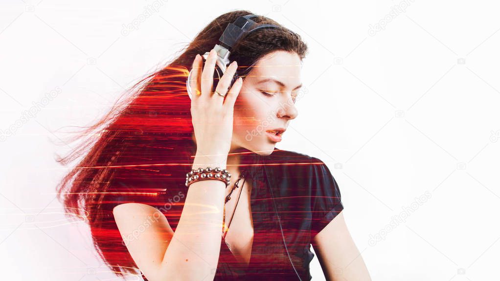 Girl fan sings and dances listening to music. Young brunette woman in big headphones enjoys music
