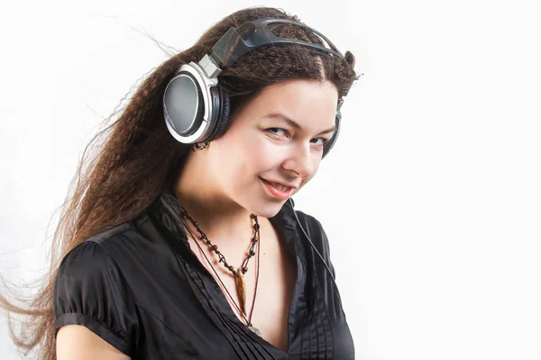 Молодая стильная женщина в больших наушниках слушает музыку и веселится . — стоковое фото