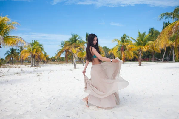 Jeune femme en maillot de bain et jupe fluide, dansant sur une plage des Caraïbes . — Photo