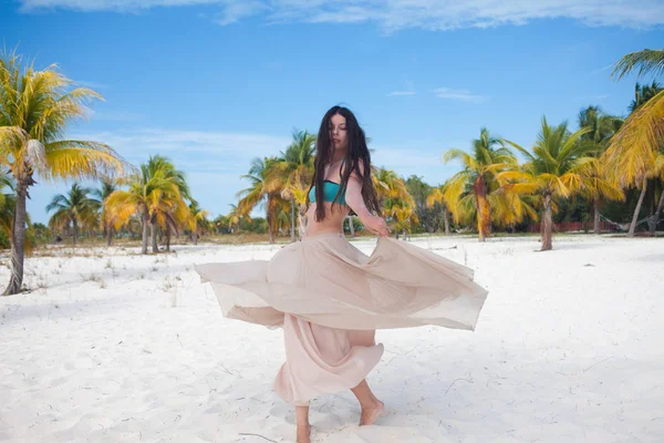 Fille voyage à la mer et est heureux. Jeune femme brune attrayante dansant agitant sa jupe contre le paysage tropical — Photo