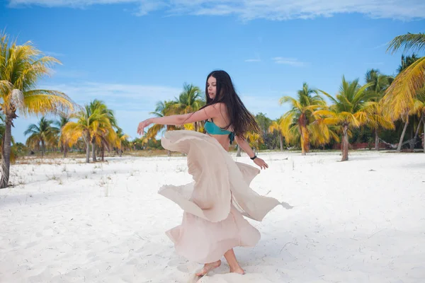 Jeune femme en maillot de bain et jupe fluide, dansant sur une plage des Caraïbes . — Photo