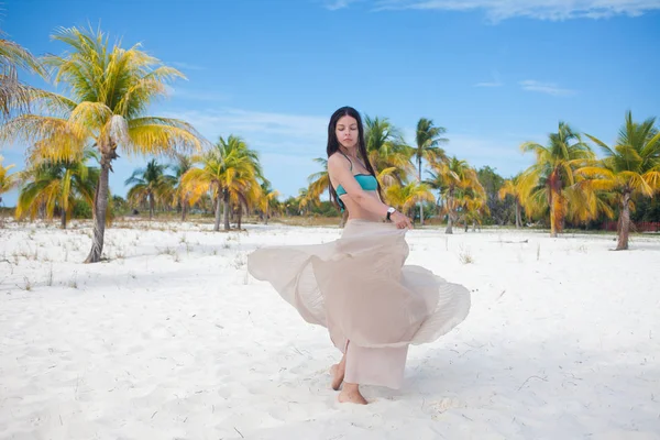 Jeune femme en maillot de bain et jupe fluide, dansant sur une plage des Caraïbes . — Photo