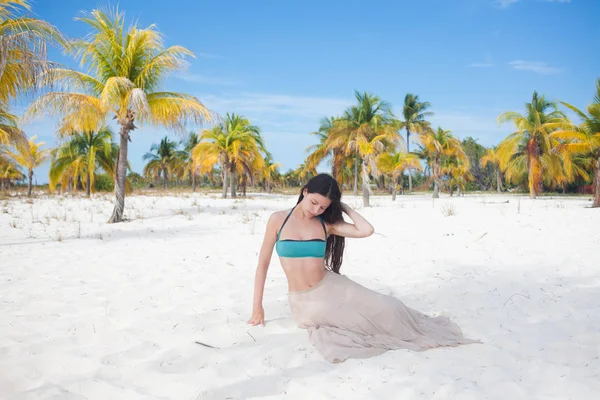 Mujer joven en traje de baño y falda que fluye, bailando en una playa caribeña . — Foto de Stock