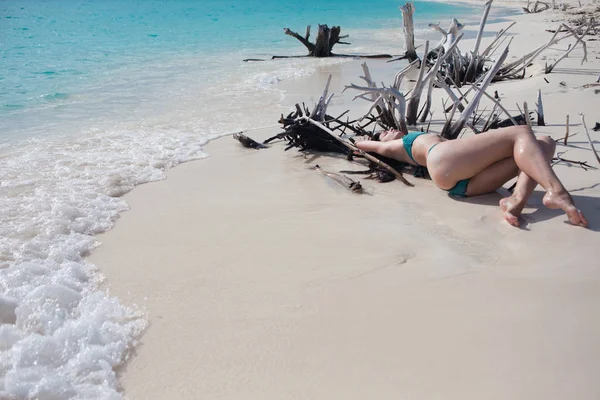 Belle fille en bikini couché parmi les épines de bois sur la plage — Photo