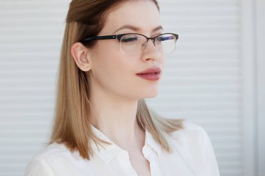 Beyaz gömlek ve gözlük genç bir şık iş kadını Portresi.