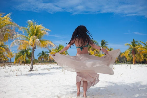 Fille voyage à la mer et est heureux. Jeune femme brune attrayante dansant agitant sa jupe contre le paysage tropical — Photo