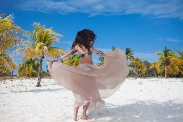 Fille voyage à la mer et est heureux. Jeune femme brune attrayante dansant agitant sa jupe contre le paysage tropical — Photo