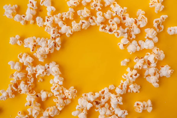 delicious popcorn scattered on a yellow background