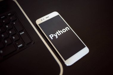 Mobil geliştirme için programlama dili Python, kavram. Dizüstü bilgisayarın yanındaki akıllı telefon