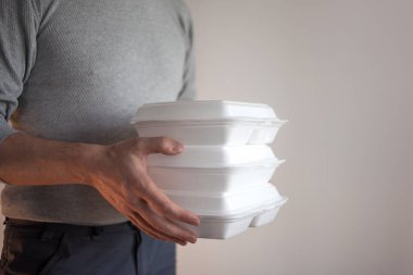 Yemek teslimatı. Bir kutu yiyecek tutan kurye adam..