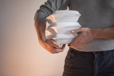 Yemek teslimatı. Bir kutu yiyecek tutan kurye adam..