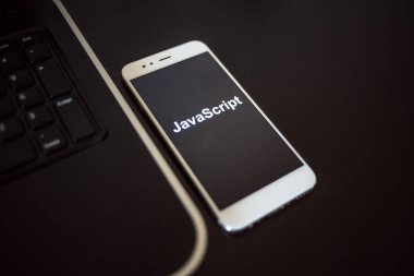 Mobil geliştirme, konsept için programlama dili JavaScript. Laptop yakınında Smartphone
