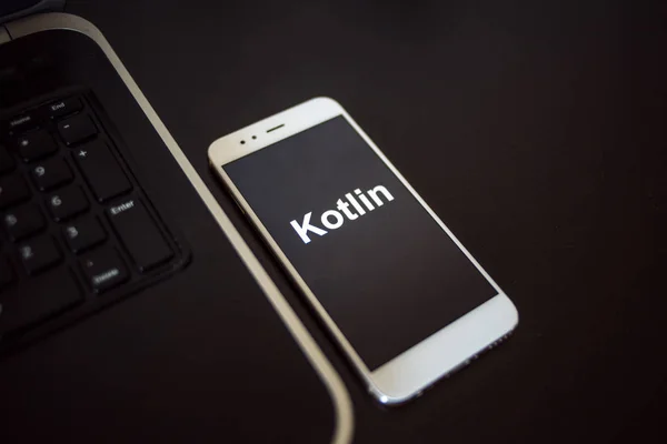 Язык программирования Kotlin для разработки мобильных устройств, концепция. Смартфон рядом с ноутбуком — стоковое фото