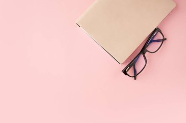 Kırtasiye, beyaz akıllı telefon, Gözlük, kalem, cüzdan, saat, takvim, defter. Pembe arka plan.