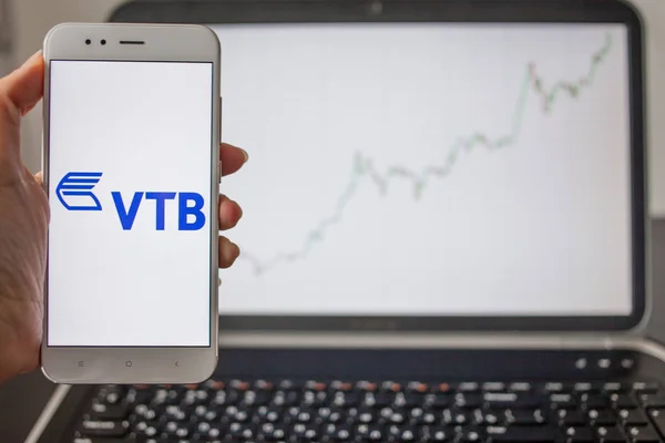 SAN PETERSBURG, RUSIA - 14 DE MAYO DE 2019: logotipo del banco ruso VTB en el fondo de los gráficos bursátiles . — Foto de Stock