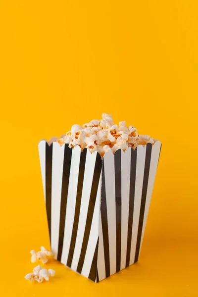 Popcorn in paper bag stand on yellow background. — Stock Photo, Image