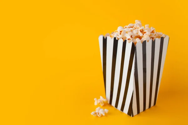 Popcorn in paper bag stand on yellow background side view — Stock Photo, Image