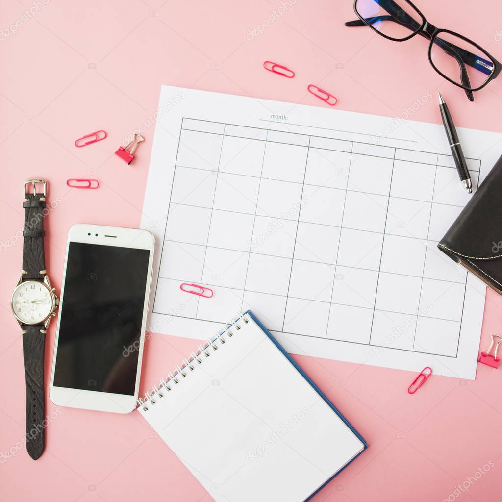 Stationery, still life with calendar and accessories, blank notebook, clock and smartphone.