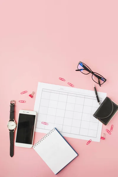 Kırtasiye, takvim ve aksesuarları ile natürmort, boş dizüstü bilgisayar, saat ve akıllı telefon.