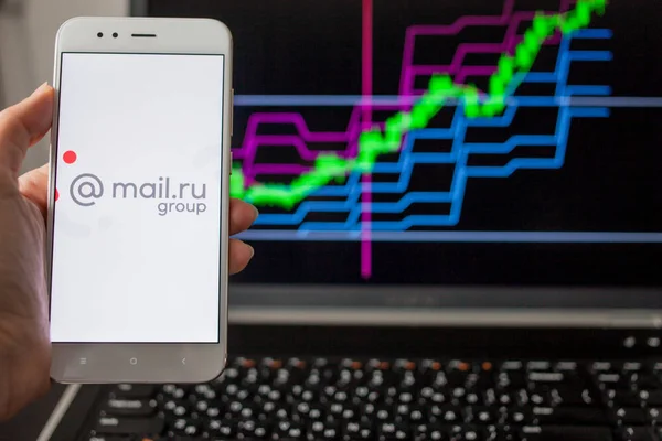 САЙНТ-ПЕТЕРБУРГ, РОССИЯ - 14 мая 2019 года: логотип российской компании mail.ru group на фоне фондовых графиков . — стоковое фото