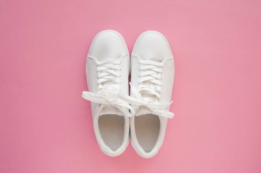 Mükemmel beyaz Yeni spor ayakkabıları parlak pembe arka plan üzerinde duruyor.