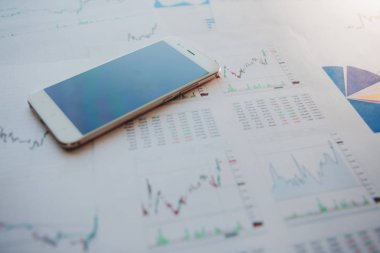 Menkul Kıymetler, konsept yatırım. Yatırımcıları için mobil uygulamalar. Finansal raporların arka planında Smartphone