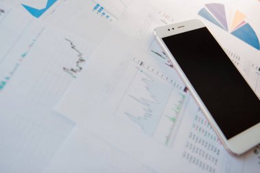 Menkul Kıymetler, konsept yatırım. Yatırımcıları için mobil uygulamalar. Finansal raporların arka planında Smartphone