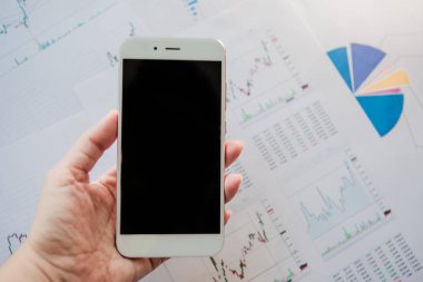 Menkul Kıymetler, konsept yatırım. Yatırımcıları için mobil uygulamalar. Finansal raporların arka planında Smartphone