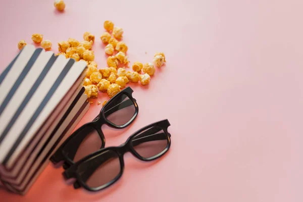 Два черных 3d очки лежат рядом с черно-белым papper полосатой коробке попкорна — стоковое фото