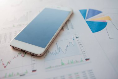 Menkul Kıymetler, konsept yatırım. Yatırımcıları için mobil uygulamalar. Finansal raporların arka planında Smartphone