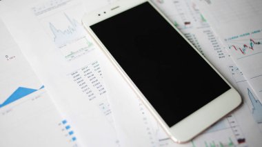 Menkul Kıymetler, konsept yatırım. Yatırımcıları için mobil uygulamalar. Finansal raporların arka planında Smartphone