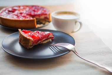 Hala bir fincan kahve ve çilek ile tatlı tatlı ile hayat, üst jöle içinde çilek dilimleri ile cheesecake kek.