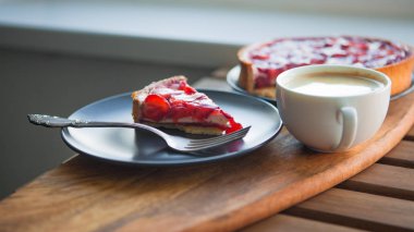 Çilek, cheesecake kek ile bir fincan kahve ve tatlı tatlı ile hala hayat