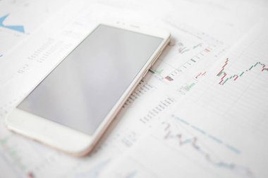 Menkul Kıymetler, konsept yatırım. Yatırımcıları için mobil uygulamalar. Finansal raporların arka planında Smartphone