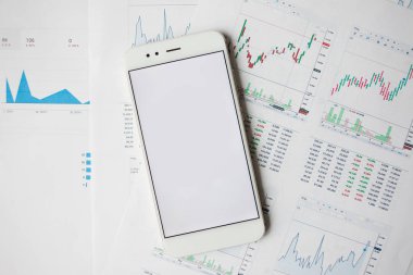 Menkul Kıymetler, konsept yatırım. Yatırımcıları için mobil uygulamalar. Finansal raporların arka planında Smartphone