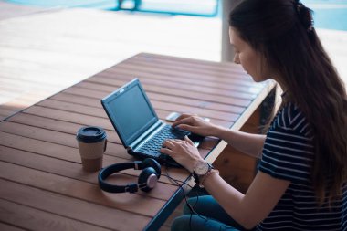 Kulaklık odaklı özenli kadın laptop ile masada oturur, ekranda görünüyor, online çalışma kursu, kendi kendine eğitim.