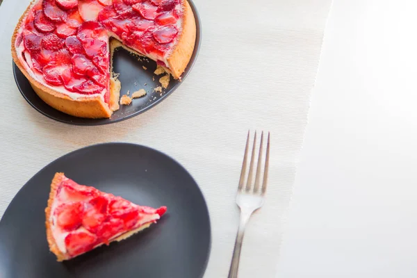 Sweet dessert with strawberries, cheesecake cake with slices of berries in jelly on top.