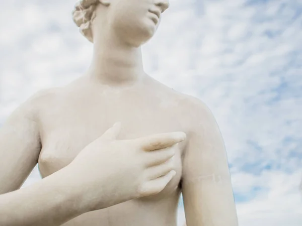 Female sculpture, fragment. Close-up of female hand covers breast, concept of female breast health problems