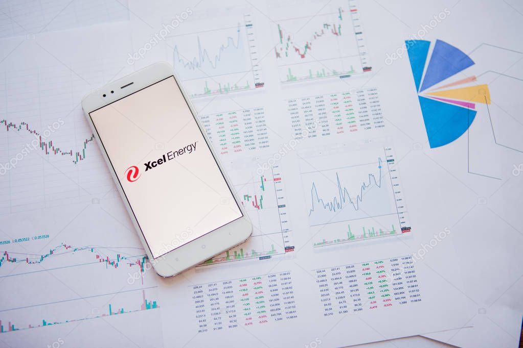 SAINT PETERSBURG, RUSSIA - JUNE 25, 2019: Xcel Energy logo on smartphone screen. Against background of stock prices, stock chart. Investments in securities.Xcel Energy Illustrative editorial