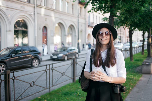 Giovane donna col cappello che cammina in città. Ragazza turista gode la passeggiata . — Foto Stock