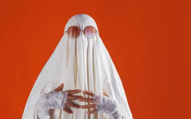 Cadılar Bayramınız Kutlu Olsun. Parlak turuncu arka planda sevimli komik Ghost
